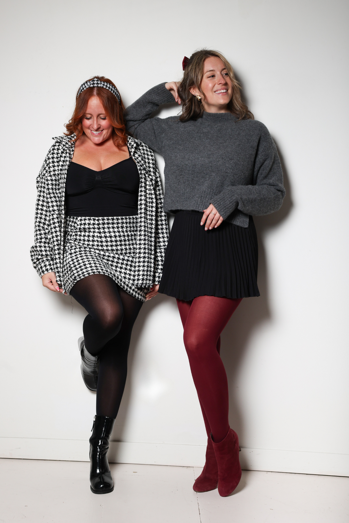 Deux femmes debout côte à côte en studio, l'une portant les collants Deluxe Indéchirables noir Signé Sarah, l'autre les Deluxe Indéchirables bourgogne avec des bottines assorties